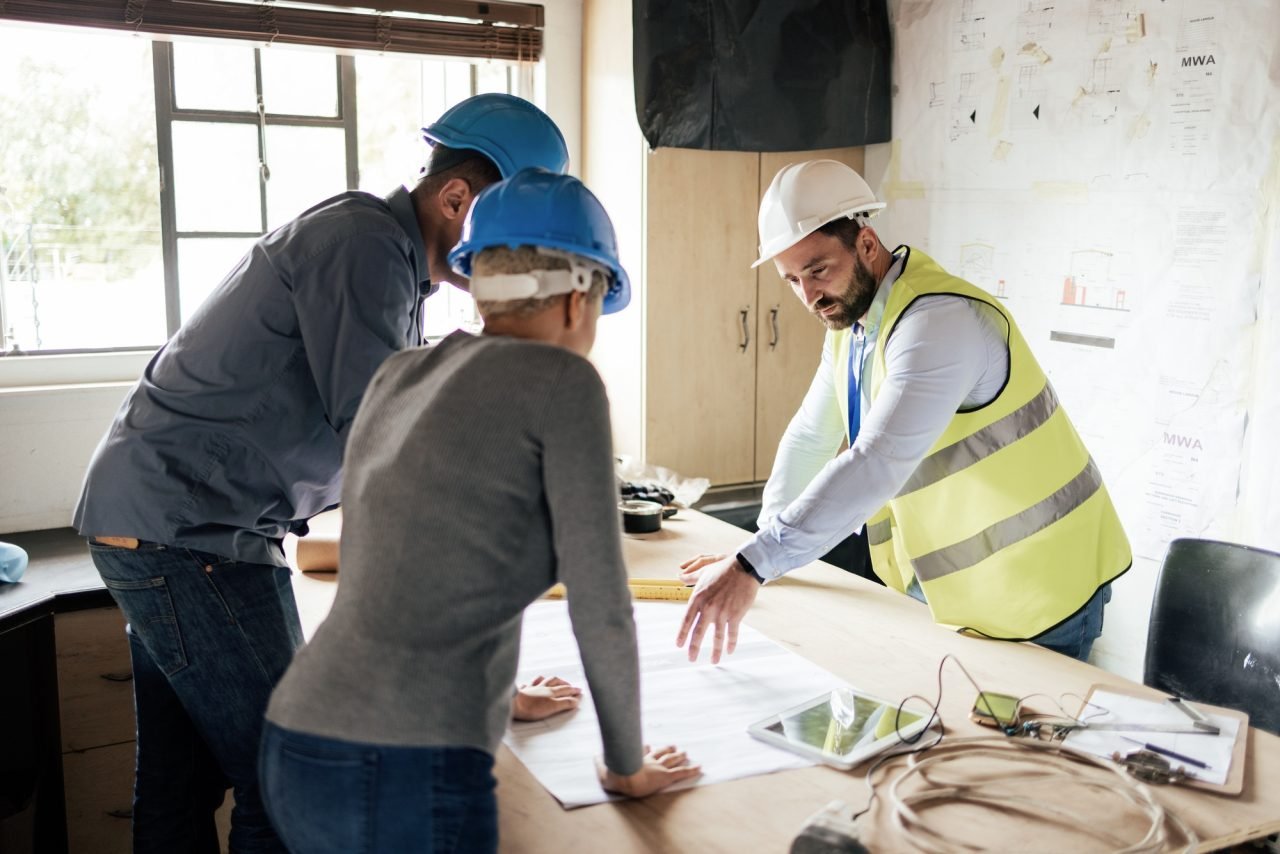 Construction workers, teamwork collaboration and blueprint planning in house, home or office buildi