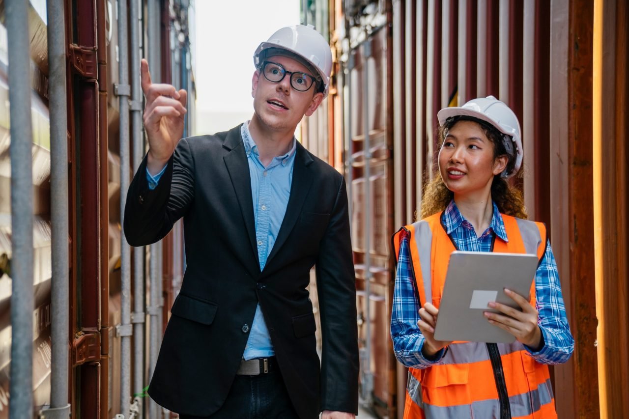 Manager and container worker working in the construction container yard