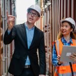 Manager and container worker working in the construction container yard