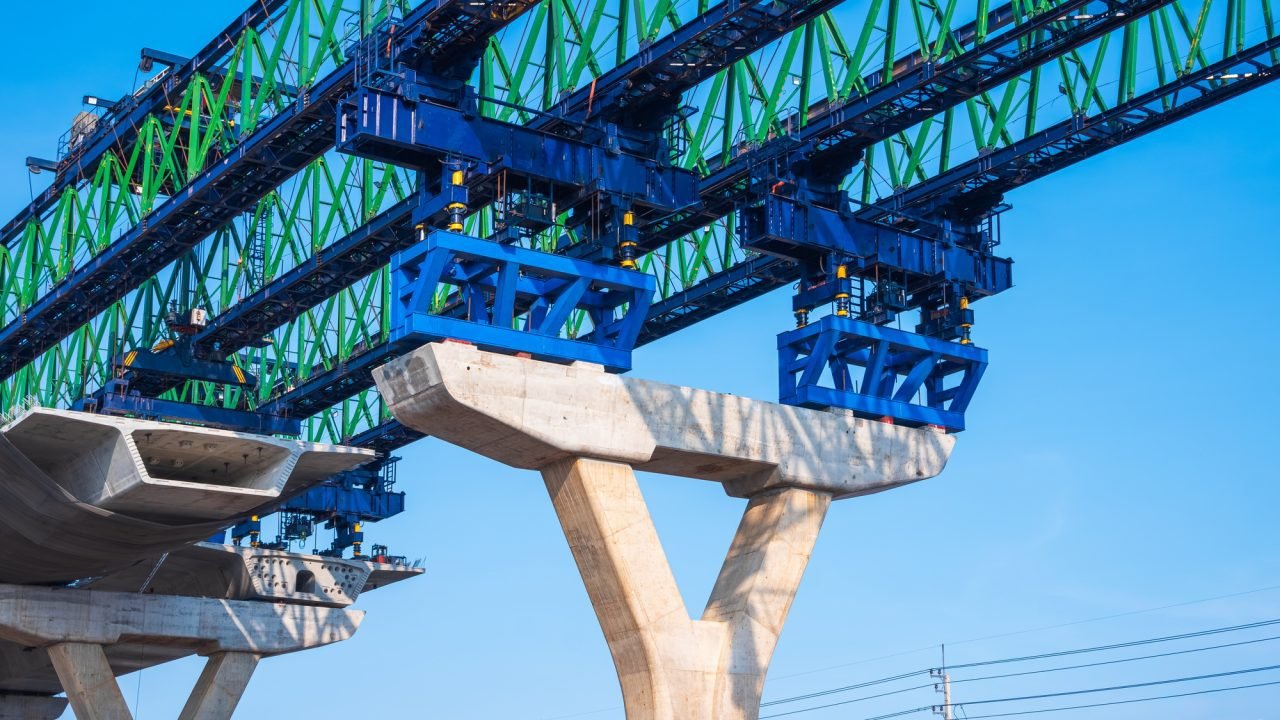 Metal launching gantry structure on foundation of flyover expressway against blue sky background