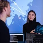 Smiling cyber security team working in a Cyber Security Operations Center SOC to protect systems and