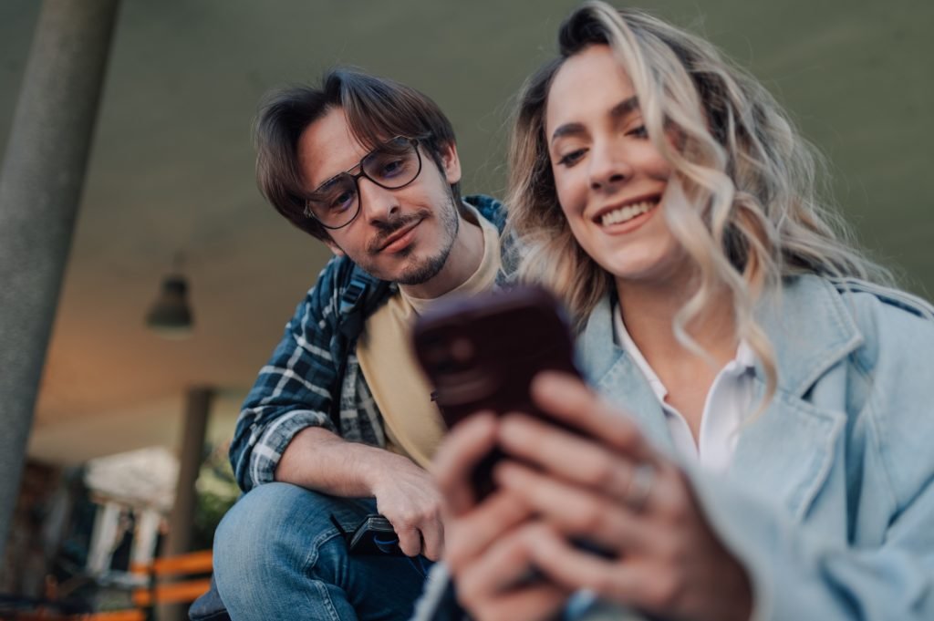 Students sharing social media content on smartphone outdoors